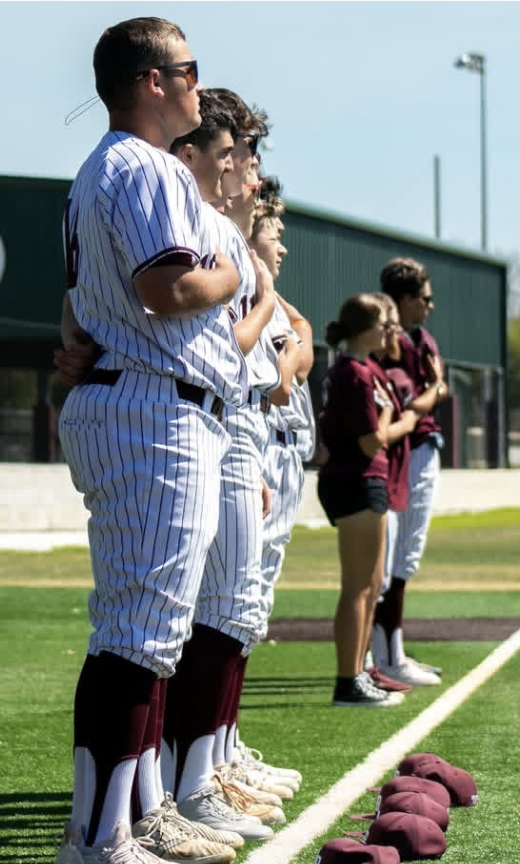 The team stood along the foul line during the national anthem.
